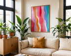 Rainbow waves wall art above a neutral sofa surrounded by plants