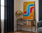 Neon abstract print styled on a black console beside a gold lamp